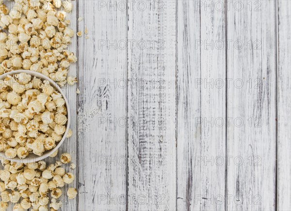 Fresh made Popcorn on a vintage background as detailed close-up shot