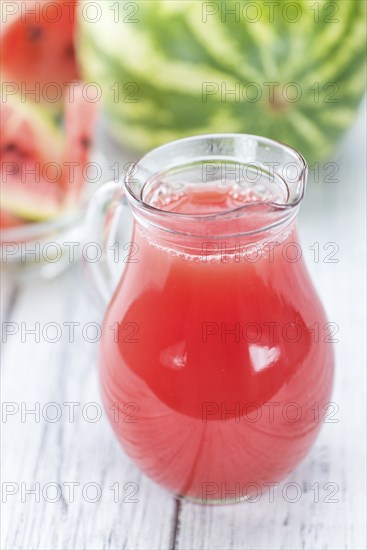 Homemade Watermelon Smoothie on an wooden table (selective focus) as detailed close-up shot