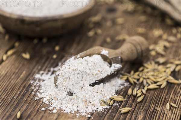 Vintage wooden table with Oat Flour (selective focus, close-up shot)