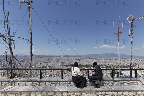 Lycabettus, Lykavittos panoramic terrace, couple looking at city panorama, Athens, Greece, Europe