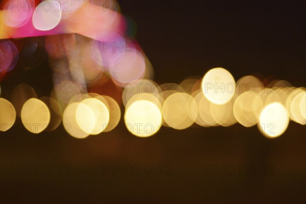 An abstract image featuring blurred lights in circular bokeh patterns with a warm and dreamy atmosphere, Abstract bokeh lights of various colors glowing against a dark background, Bokeh light on road