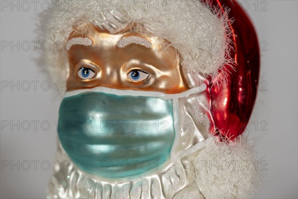 Symbolic image of Christmas in the Corona crisis, Father Christmas figure, Christmas tree decoration, with mouth and nose mask, everyday mask