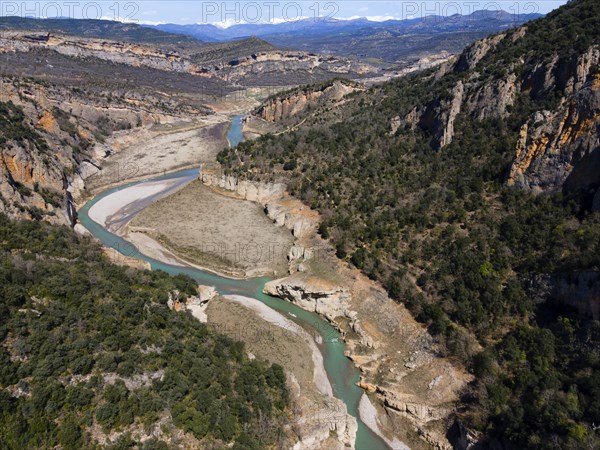 An aerial view of a deep gorge with a green river surrounded by steep, wooded cliffs, aerial view, Congost de Mont-rebei gorge, Noguera Ribagorçana Mont-rebei Natural Park, Montsec mountain range, Noguera Ribagorçana river, Lleida province, Catalonia, Aragon, Spain, Europe