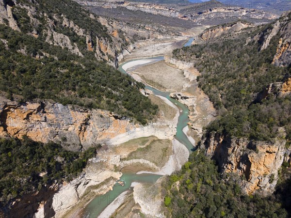 An aerial view of a rocky gorge with a winding river and densely overgrown cliffs, aerial view, Congost de Mont-rebei gorge, Noguera Ribagorçana Mont-rebei Natural Park, Montsec mountain range, Noguera Ribagorçana river, Lleida province, Catalonia, Aragon, Spain, Europe