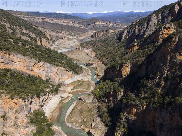 A river meanders through an extensive mountain landscape with deep canyons and lots of vegetation, aerial view, Congost de Mont-rebei gorge, Noguera Ribagorçana Mont-rebei nature park Park, Montsec mountain range, Noguera Ribagorçana river, Lleida province, Catalonia, Aragon, Spain, Europe