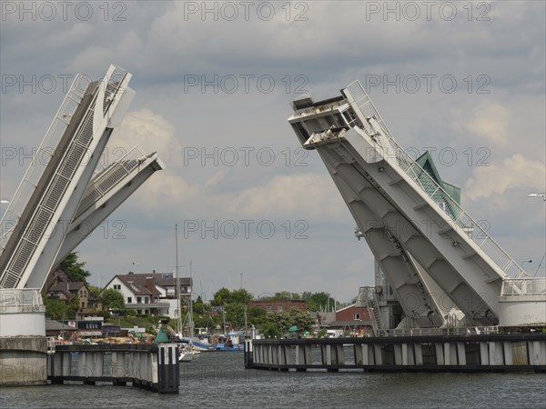 Bascule bridge over the harbour in open state, with boats and buildings along the shore under a cloudy sky, Kappeln, Schleswig-Holstein, Germany, Europe