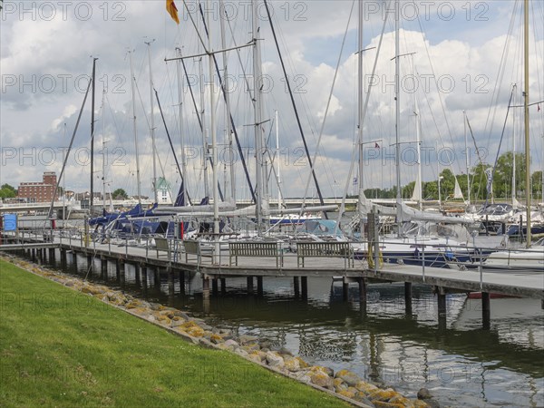 Sailboats dock at the marina in a partly cloudy sky with manicured lawn, Kappeln, Schleswig-Holstein, Germany, Europe