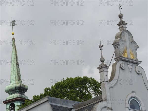 Close-up of a church with ornate spires and a weather vane in front of a grey sky, Kappeln, Schleswig-Holstein, Germany, Europe