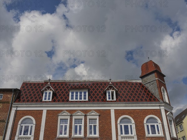 Historic building with red roof tiles under a cloudy sky, Kappeln, SChleswig-Holstein, Germany, Europe