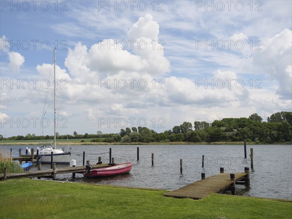 A calm harbour picture with boats at the jetty and a cloudy sky above the trees in the background, Kappeln, Schleswig-Holstein, Germany, Europe