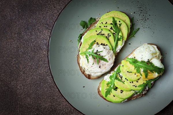 Sandwich with cream cheese, sliced avocado and boiled egg, arugula, on grainy bread, homemade, breakfast, no people