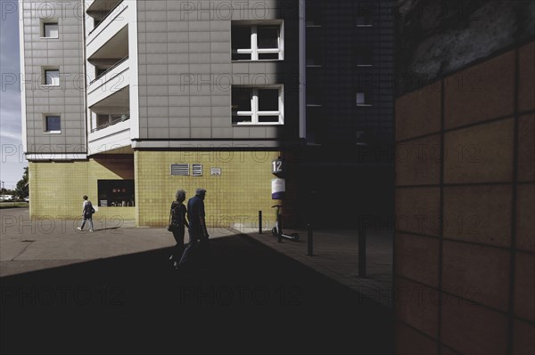 Two elderly people are silhouetted in front of a block of flats in Marzahn, taken in Berlin, 07/08/2024