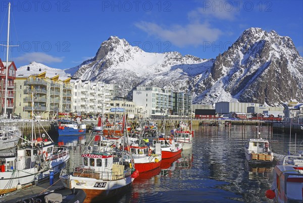 Colourful boats in the harbour, surrounded by snow-covered mountains and a lively town, fishing, Lofoten, Svolvaer, Nordland, Arctic, Norway, Europe