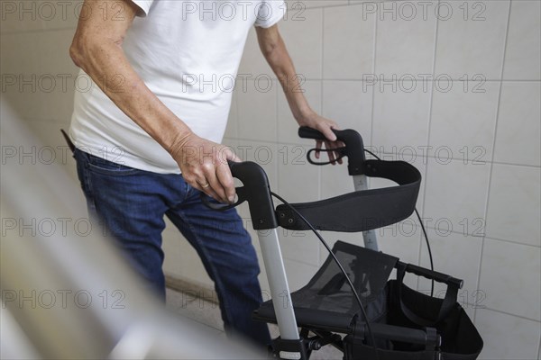 An elderly man walks with a rollator through a hallway in Berlin, 05/08/2024