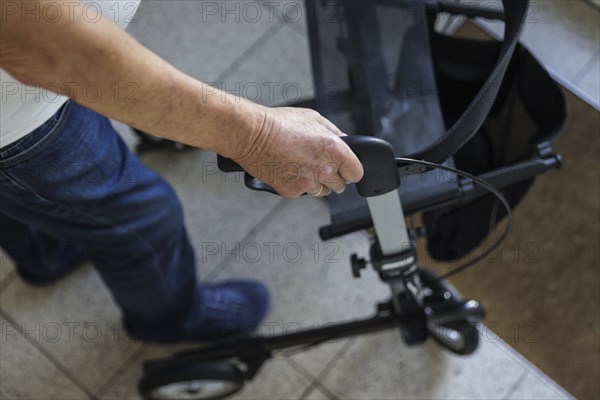 An elderly man walks with a rollator through a hallway in Berlin, 05/08/2024