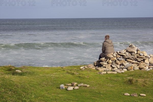 A woman looks out to sea on a stormy day along the Wild Atlantic Way Strandhill, Sligo, Ireland, Europe