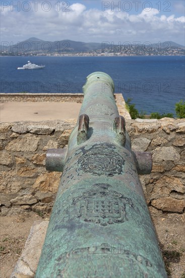 Historic cannon of the citadel of Saint-Tropez, built in 1602 for defence against the Ottoman Empire, behind it bay with yacht, Saint Tropez, Provence-Alpes-Côte d'Azur, France, Europe