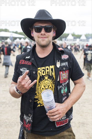 Festival visitor with a French fries fork (as a hand sign and in the waistcoat) at the Wacken Open Air in Wacken. The traditional metal festival takes place from 31 July to 3 August 2024