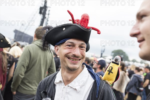 Festival visitor dressed as a pirate with parrot and octopus at the Wacken Open Air in Wacken. The traditional metal festival takes place from 31 July to 3 August 2024