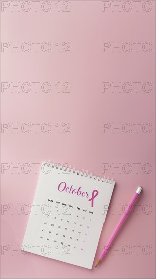 October calendar with a breast cancer awareness pink ribbon and a pencil with copyspace. Vertical shot, AI generated