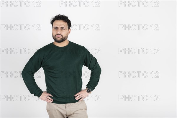 Man with arms akimbo stares accusingly at the camera