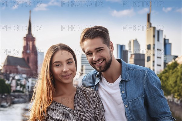 A smiling couple in front of a city skyline with modern buildings and a church tower in the background, ai generated, KI generated, AI generated