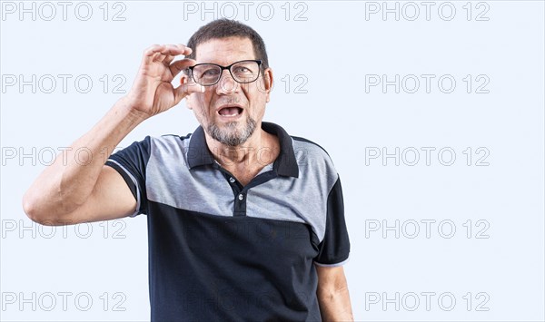 Amazed senior man taking off glasses isolated. Surprised senior man taking off glasses looking at camera