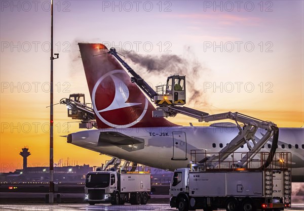 Frost at the airport, a Turkish Airlines aircraft is de-iced in front of sunrise. Airbus A321-231, Fraport, Frankfurt am Main, Hesse, Germany, Europe