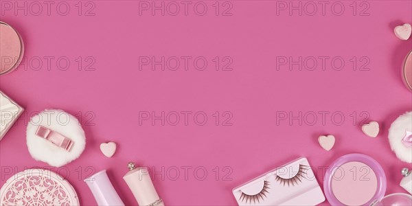 Banner with cute pink makeup beauty products like brushes, powder or lipstick on sides of pink background with empty copy space in middle