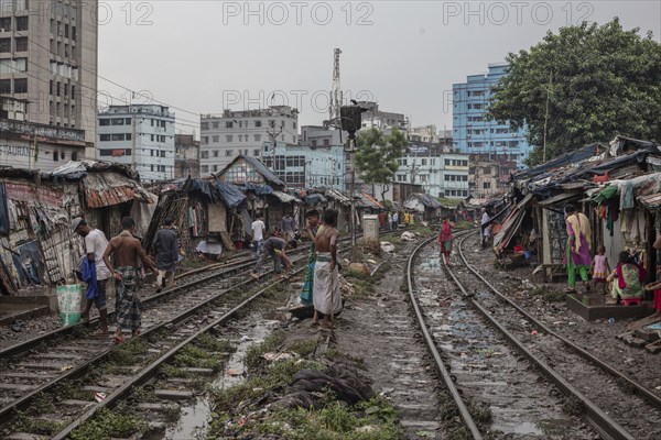 Father with his son walking on the railway tracks, Tejgaon Slum Area, Dhaka, Bangladesh, Asia