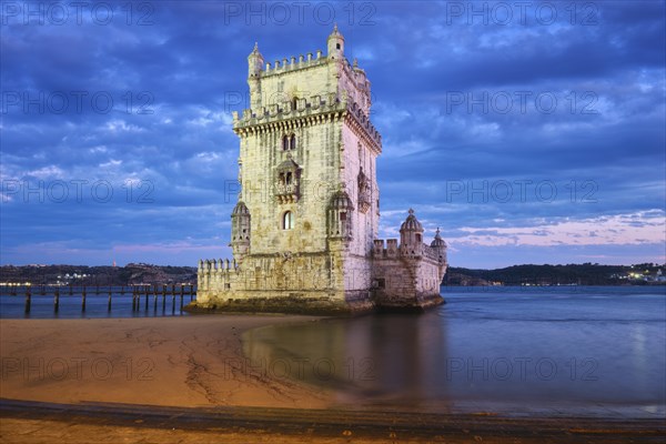 Belem Tower or Tower of St Vincent, famous tourist landmark of Lisboa and tourism attraction, on the bank of the Tagus River (Tejo) after sunset in dusk twilight with dramatic sky. Lisbon, Portugal, Europe