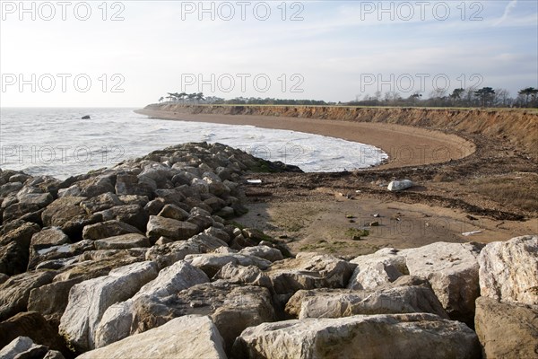 Rock armour boulders used as coastal defence against rapid erosion at East Lane, Bawdsey, Suffolk, England, UK