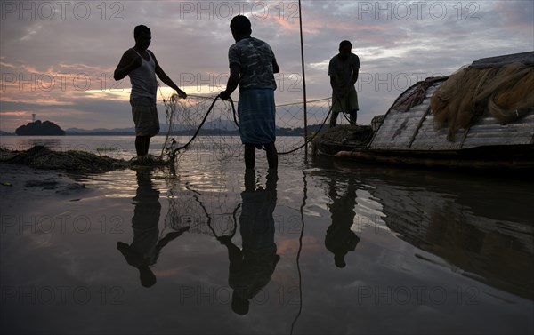 Fishermen cleaning their fishing nets after fish in the Brahmaputra river, in Guwahati, Assam, India on Wednesday, 09 October 2019