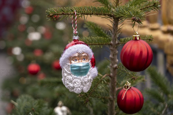 Symbolic image of Christmas in the Corona crisis, Father Christmas figure, Christmas tree decoration, with mouth and nose mask, everyday mask