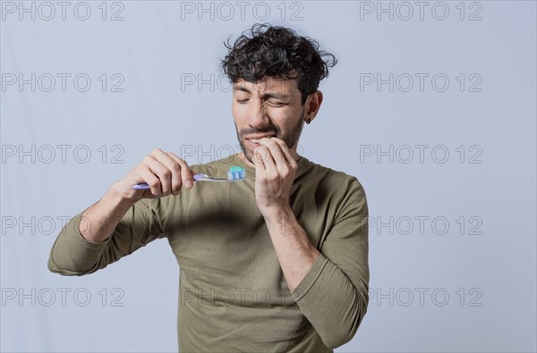 Person with gingivitis holding toothbrush. People holding toothbrush with gum pain. Man holding toothbrush with gum pain