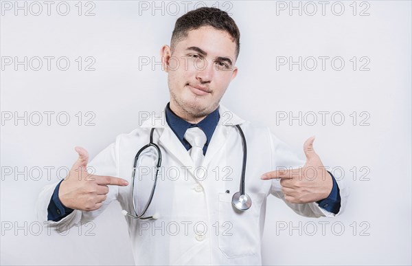 Cheerful doctor pointing at himself isolated. Satisfied young doctor pointing at himself on isolated background