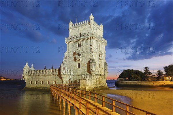 Belem Tower or Tower of St Vincent, famous tourist landmark of Lisboa and tourism attraction, on the bank of the Tagus River (Tejo) after sunset in dusk twilight with dramatic sky. Lisbon, Portugal, Europe