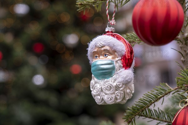 Symbolic image of Christmas in the Corona crisis, Father Christmas figure, Christmas tree decoration, with mouth and nose mask, everyday mask