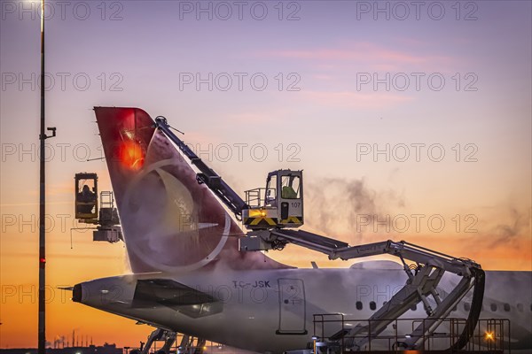 Frost at the airport, a Turkish Airlines aircraft is de-iced in front of sunrise. Airbus A321-231, Fraport, Frankfurt am Main, Hesse, Germany, Europe