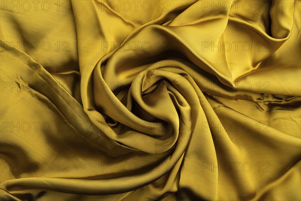 Fragment of yellow and green tissue. Side view, synthetic textile background and texture. wave concept, abstract