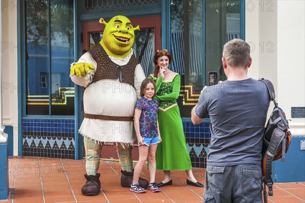 Man photographing daughter with Shrek and Princess Fiona at Universal Studios theme park in Orlando, Florida, USA, North America