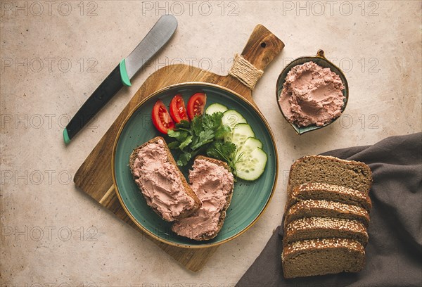 Liver meat pate spread on rye bread, breakfast, close-up, beige background. no people, selective focus