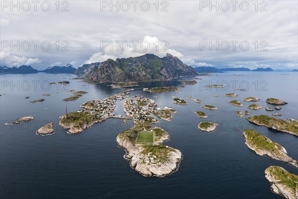 Aerial view, Henningsvaer with football pitch, rocky islands in the sea off Bergen, Festvagtinden, Vestvagoy, Lofoten, Norway, Europe