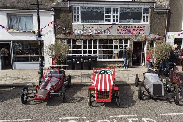 Traditional soapboxes parked by the roadside in the town centre, Lafrowda Festival 2023, St Just in Penwith, Cornwall, England, United Kingdom, Europe