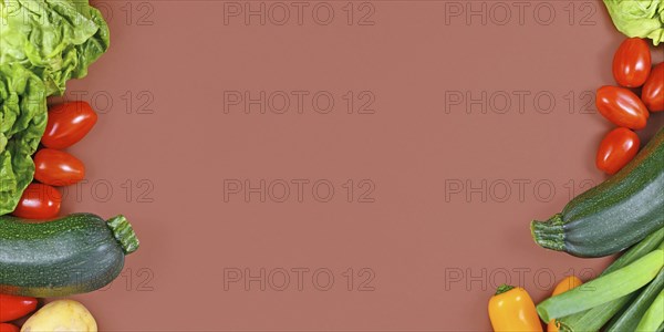 Banner with healthy vegetables with salad, zucchini, tomatoes, potatoes and bell pepper framing blank brown background with copy space