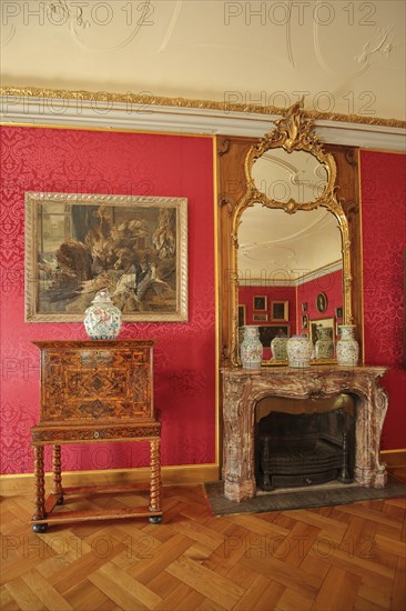 Red drawing room with chest of drawers, painting, wall mirror, parquet floor and fireplace, interior view, room, castle, Lichtenwalde, Niederwiesa, Saxony, Germany, Europe