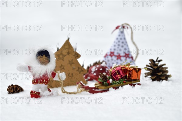 Christmas decoration, Inuit pulling sleigh with Christmas presents through the snow