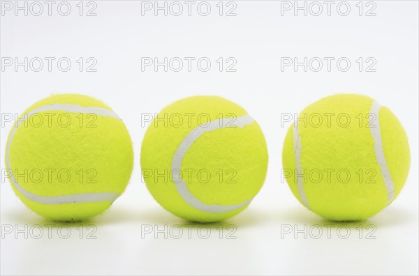 Sports equipment, three yellow tennis balls in a row