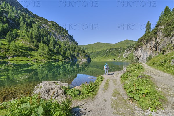 Hikers at Tappenkarsee, reflection, mountain lake, Radstätter Tauern, landscape conservation area, Kleinarl, Pongau, Salzburg