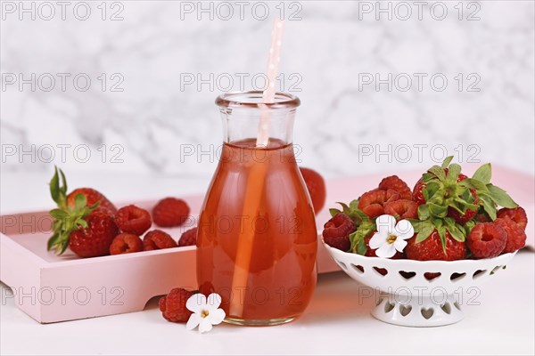 Strawberry fruit lemonade in jar surrounded by berries